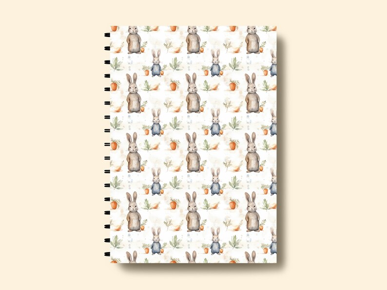 May include: A white spiral bound notebook with a repeating pattern of watercolor bunnies, leaves, and carrots.