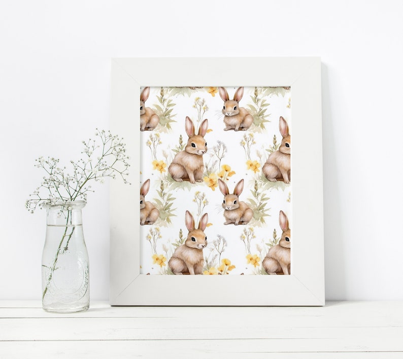 May include: A white framed print with a repeating pattern of brown rabbits and yellow flowers on a white background.