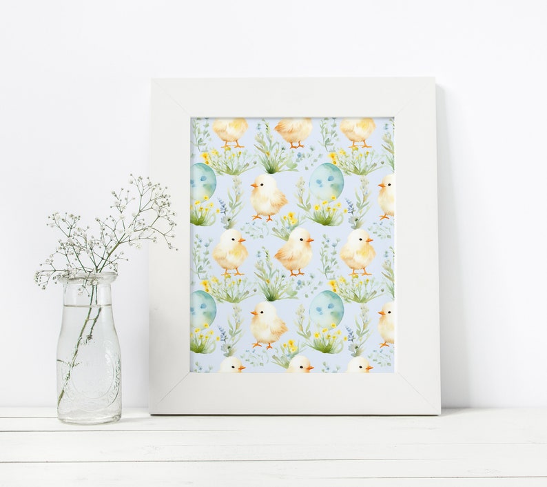 May include: A white frame with a blue background and a repeating pattern of yellow chicks, green leaves, and blue eggs. The chicks are facing different directions and have yellow beaks and feet.