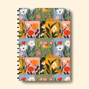 May include: A spiral bound notebook with a colourful floral pattern. The cover features a patchwork design of squares with different coloured backgrounds and various flowers in shades of pink, red, yellow, white, and green.