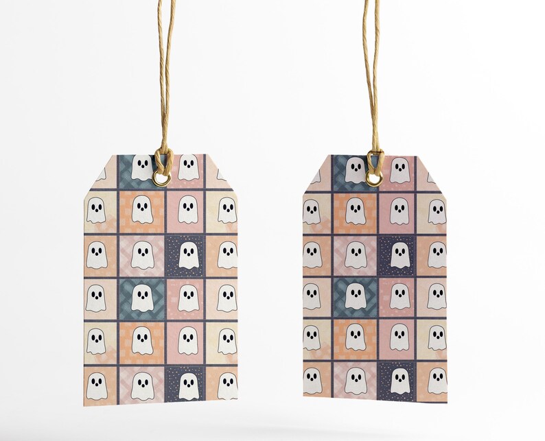 May include: Two gift tags featuring a repeating pattern of white cartoon ghosts on a patchwork background of pink, peach, blue, and navy squares. Each tag is rectangular with a rounded top and a hole for a natural twine string.