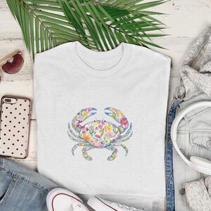White t-shirt with a colorful floral crab graphic, flat lay.