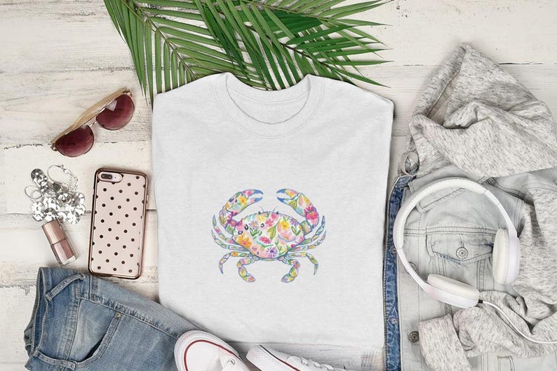 White t-shirt with a colorful floral crab graphic, flat lay.