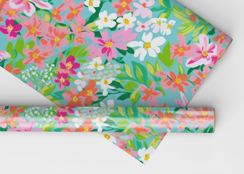 K&ouml;nnte beinhalten: Eine Rolle blaues Geschenkpapier mit einem Blumenmuster mit rosa, orange, wei&szlig;en und gr&uuml;nen Blumen.