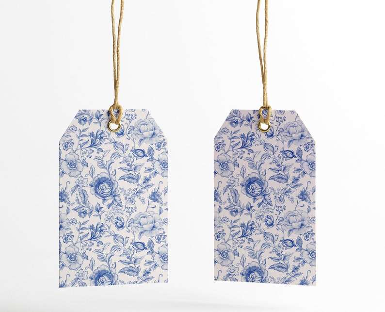 May include: Two white gift tags with blue floral patterns and gold eyelets. The tags are hanging from twine.