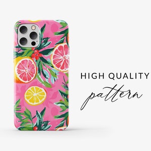 May include: A pink phone case with a colorful pattern of lemons, grapefruits, and green leaves. The case has a cutout for the camera lens.