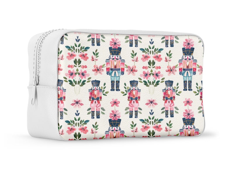May include: White zippered pouch with a repeating pattern of pink flowers and watercolor nutcracker soldiers.