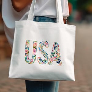 White tote bag with colorful floral letters spelling "USA".