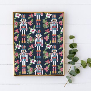 Pu&ograve; includere: Una stampa incorniciata con un motivo ripetitivo di soldati schiaccianoci e fiori tropicali su uno sfondo blu scuro. Gli schiaccianoci indossano uniformi rosse, blu e dorate e i fiori sono rosa, bianchi e verdi.