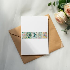 Card with mahjong tiles and roses on a brown envelope.