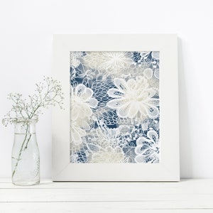 May include: A framed print featuring a white floral design on a blue background. The flowers are intricate and detailed, with soft, muted colours.
