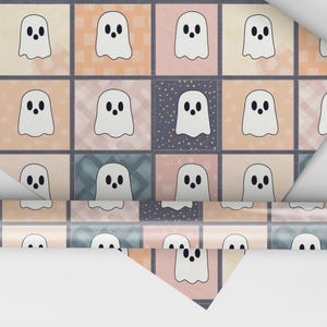 May include: A roll of patterned paper with a repeating design of white ghost figures on a patchwork background of pastel squares. The squares are in shades of pink, peach, and blue, with a hint of a grid pattern.