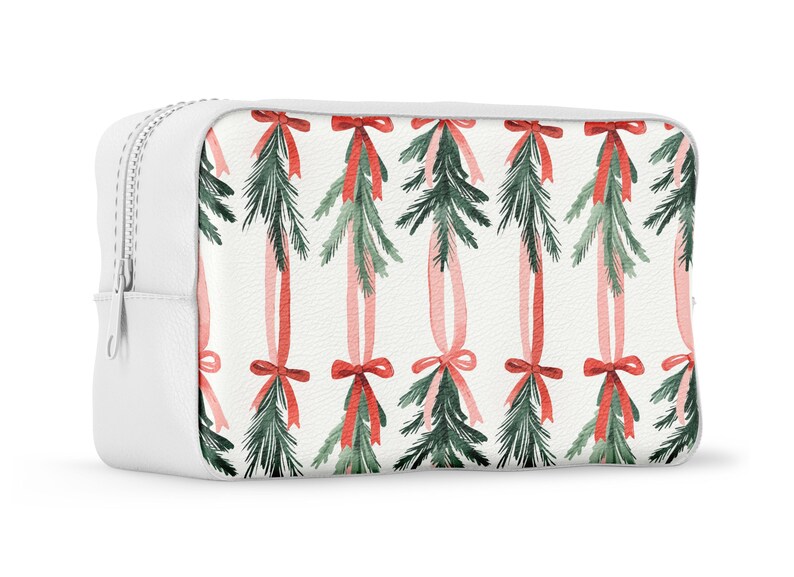 K&ouml;nnte beinhalten: Wei&szlig;e Kosmetiktasche mit Rei&szlig;verschluss und einem sich wiederholenden Muster aus gr&uuml;nen Kiefernzweigen, die mit roten und rosa B&auml;ndern gebunden sind.