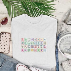 White t-shirt with colorful mahjong tiles, sunglasses, headphones, and jeans.
