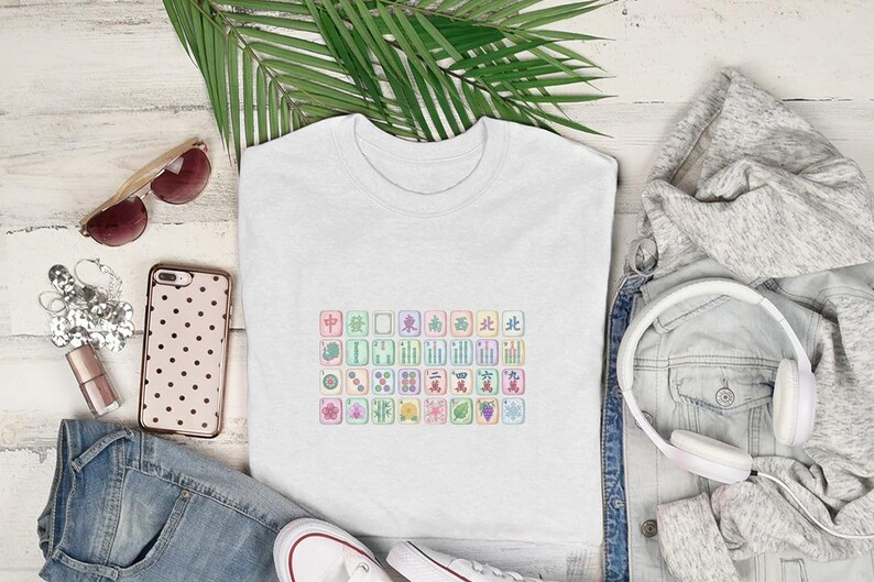 White t-shirt with colorful mahjong tiles, sunglasses, headphones, and jeans.