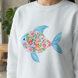 White sweatshirt with a colorful floral fish graphic.