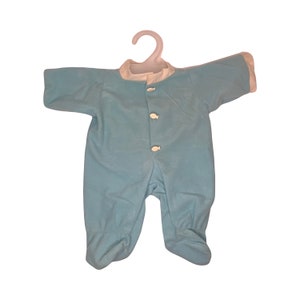 May include: A light blue baby onesie with white trim and white fish-shaped buttons.