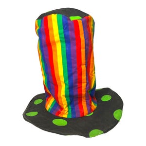 Puede incluir: Un sombrero alto con rayas de arcoíris, un borde negro y lunares verdes.