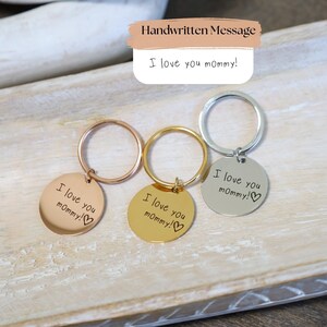 May include: Three keychains with round metal tags that say "I love you mommy!" in handwritten font. The keychains are gold, rose gold, and silver.