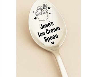 May include: A silver ice cream spoon with the text "Jose's Ice Cream Spoon" in black. The spoon features a black illustration of ice cream in a bowl with two wafer sticks. Black hearts and stars surround the illustration.