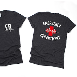 May include: Two dark heather grey t-shirts with a white graphic print. The front shirt says "ER" with a heartbeat symbol. The back shirt says "EMERGENCY DEPARTMENT" with a red cross and a heartbeat symbol.