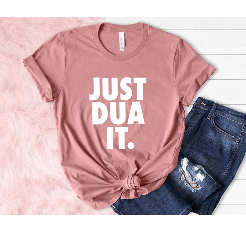 May include: A dusty rose t-shirt with the text "JUST DUA IT." printed in white.