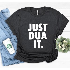 May include: A dark gray t-shirt with the text "JUST DUA IT." printed in white.