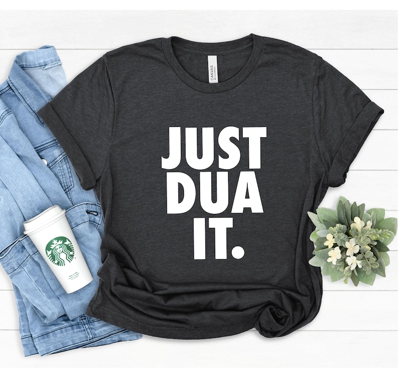May include: A dark gray t-shirt with the text "JUST DUA IT." printed in white.