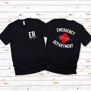 May include: Two black t-shirts with a white graphic print. The front shirt says "ER" with a heartbeat line. The back shirt says "EMERGENCY DEPARTMENT" with a red cross and a heartbeat line.