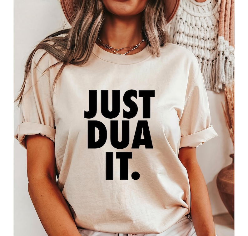 May include: A beige t-shirt with the text "JUST DUA IT." printed in black.