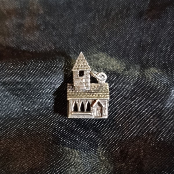A church with steeple, stanhope charm in 925 sterling silver. Lights up and projects the lords prayer.