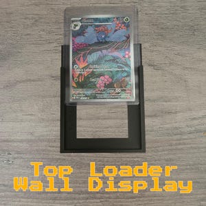 May include: Black plastic wall mount display for a trading card, featuring a clear plastic window to showcase the card. The display is labeled "Top Loader Wall Display".