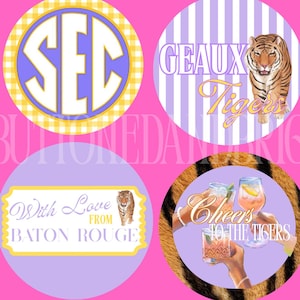 Può includere: Quattro disegni circolari su sfondo rosa. I disegni includono il testo "SEC", "GEAUX Tigers", "With Love From Baton Rouge" e "Cheers to the Tigers". Ogni disegno presenta una tigre o una stampa di tigre.