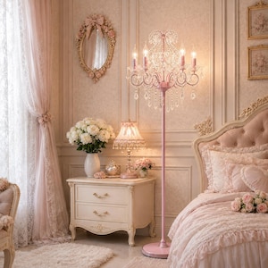 May include: A pink bedroom featuring a chandelier floor lamp, a bedside table, and a bed. The room is decorated in shades of pink and white, with floral accents and a decorative mirror. The bed has a pink headboard and is covered with a pink duvet and pillows.