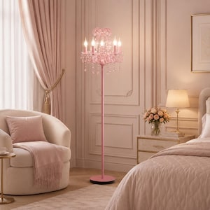 May include: A pink floor lamp with a chandelier design. The lamp has five candle-style lights and crystal accents. The lamp is in a bedroom with a cream-coloured chair, curtains, and a bed. The lamp is approximately 152 cm tall.