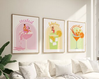 May include: Three framed illustrations of cocktails with the words "Cocktail", "Libation", and "Aperitif" above each image. Each image features a woman in a bathing suit holding a cocktail glass.
