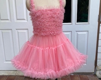 May include: A bright pink sleeveless dress featuring a bodice covered in dense, ruffled tulle layers. The skirt is constructed from multiple tiers of gathered, sheer pink tulle fabric, creating a voluminous, flared silhouette with a ruffled hem.