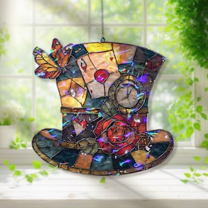 May include: Stained glass Mad Hatter's hat featuring a butterfly, playing cards, a clock, and a red rose. The hat is a mosaic of colours including blue, yellow, and brown. A decorative piece for a window or wall.