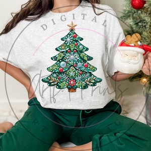 May include: A gray t-shirt with the text "DIGITAL ART FRIENDS" printed on the front. The shirt features a sparkly green Christmas tree with red and white ornaments. The person wearing the shirt is holding a white mug with a gingerbread man inside.