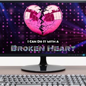 May include: A computer monitor displaying a pink broken heart-shaped disco ball with the text "I can do it with a broken heart" on a dark background with pink and blue lights.