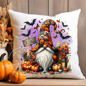 Puede incluir: Cojín cuadrado blanco con un gnomo de Halloween con una larga barba blanca y un sombrero alto decorado con calabazas. El cojín tiene un fondo púrpura con murciélagos, mariposas y la palabra "OCTUBRE" en un letrero de madera.