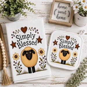 May include: A white kitchen towel and a matching square pot holder, both featuring a graphic of a fluffy sheep, yellow flowers, brown stars, and a heart with the text Simply Blessed. The items are displayed alongside a wooden sign with the text home sweet home.