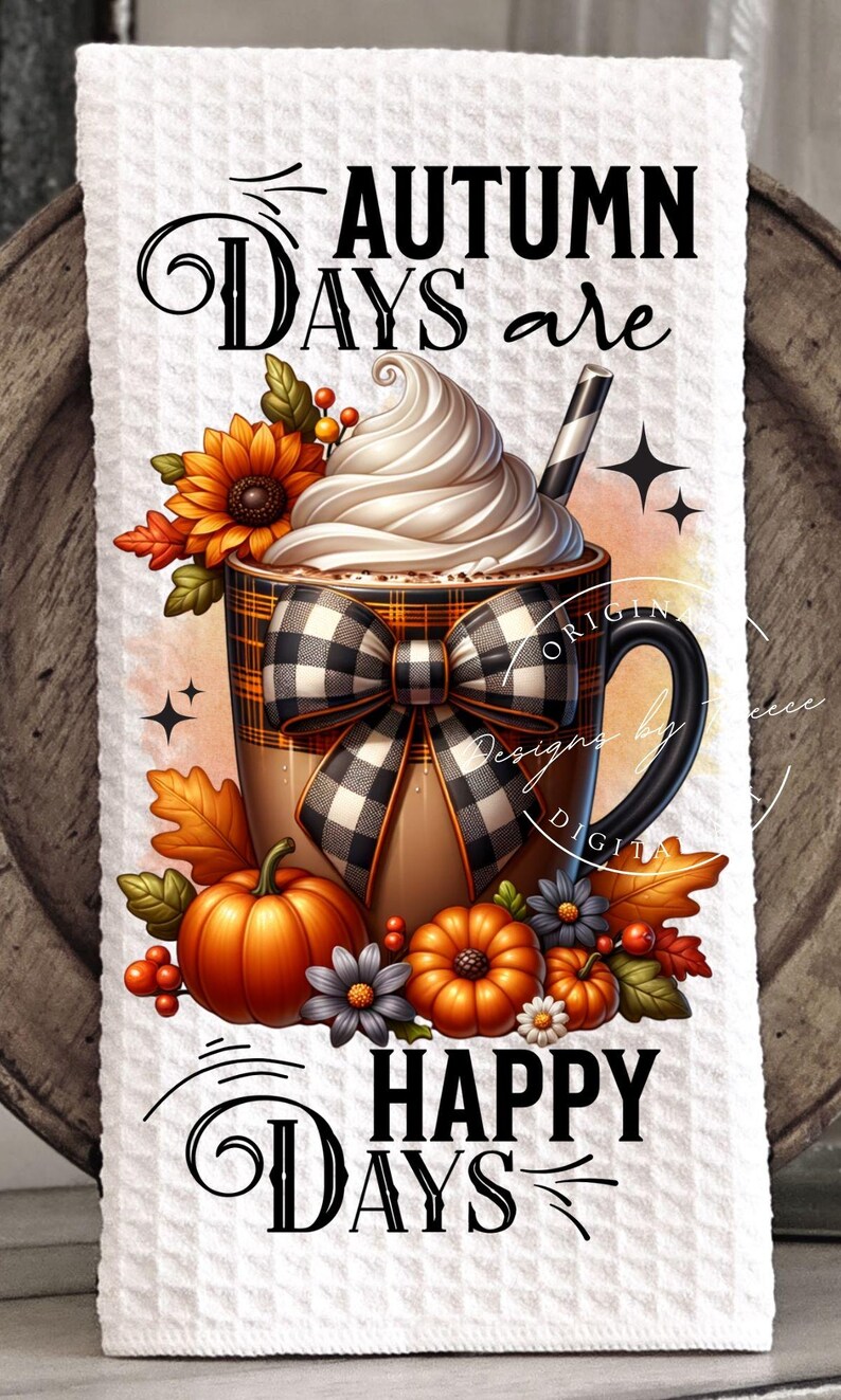 May include: A decorative kitchen towel featuring a fall-themed design. The image includes a coffee mug with whipped cream, a black and white plaid bow, pumpkins, and the text "AUTUMN DAYS are HAPPY DAYS."