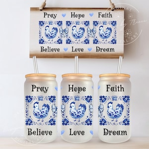 May include: Three frosted glass tumblers with bamboo lids and straws. Each tumbler features a blue and white ceramic tile design with a chicken, flowers, and the words "Pray", "Hope", and "Faith". Below each design are the words "Believe", "Love", and "Dream".