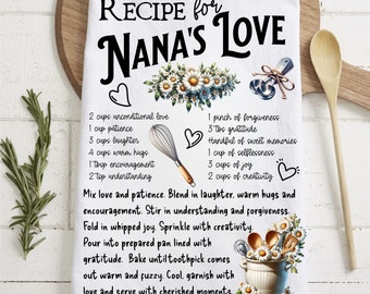 May include: White kitchen towel with a black and white recipe for "Nana's Love" printed on it. The recipe includes ingredients like unconditional love, patience, laughter, warm hugs, encouragement, understanding, forgiveness, gratitude, sweet memories, selflessness, joy, and creativity. The towel is decorated with floral illustrations and kitchen utensils.