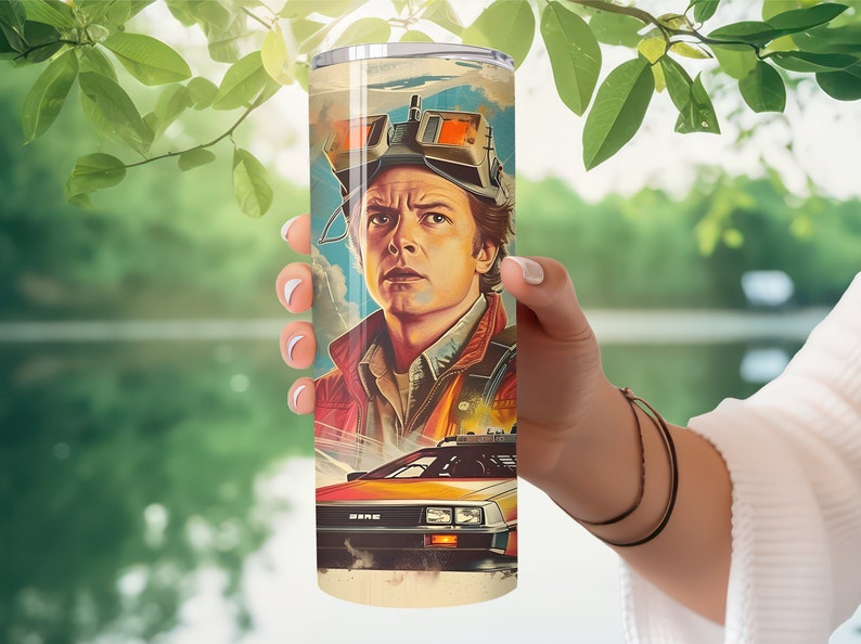 May include: A stainless steel tumbler with a colorful illustration of a man wearing goggles and a futuristic car. The man has brown hair and is wearing a red jacket. The car is a silver DeLorean with a red interior.