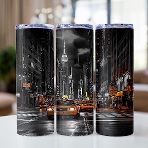 May include: Three stainless steel tumblers with a black and white cityscape design. The cityscape features tall buildings, a street with cars, and a yellow taxi cab.