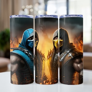 May include: Two stainless steel tumblers with a black background and images of the Mortal Kombat characters Sub-Zero and Scorpion. Sub-Zero is on the left and is wearing a blue mask and outfit. Scorpion is on the right and is wearing a yellow mask and outfit. Both characters are surrounded by flames.