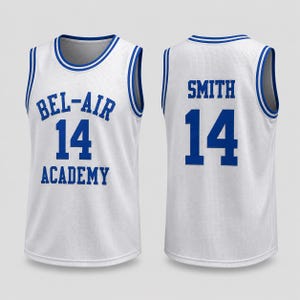May include: A white basketball jersey with blue trim on the collar and armholes. The front features the blue text BEL-AIR ACADEMY and the number 14. The back displays the name SMITH and the number 14 in blue. The fabric has a mesh texture.