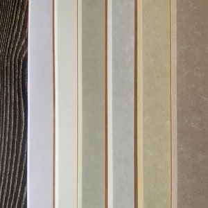 A close up of the 6 different colors of animal-free parchment paper available including white, fleece white, natural, storm, aged, and camel.  The speckled patterns of the animal-free parchment paper are shown in detail.